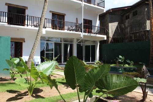 a building with a bunch of plants in front of it at PRANA Beach Hotel Hikkaduwa in Hikkaduwa