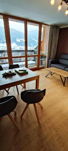 a living room with a table and chairs and a balcony at Premium Appartements Di Bora in Sankt Michael im Lungau