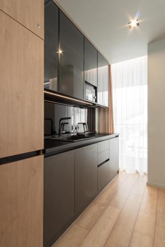a kitchen with gray cabinets and a sink at SAVOIE Apartments Bukovel in Bukovel