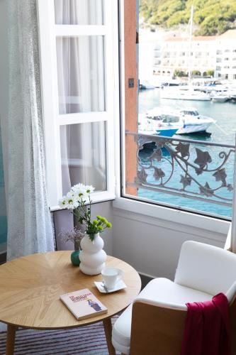 a table and chairs in a room with a window at Best Western Hotel du Roy d'Aragon in Bonifacio