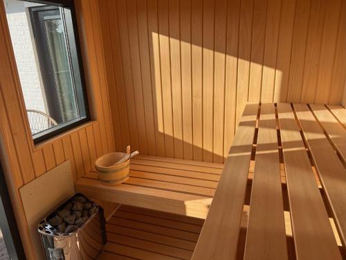 eine kleine Sauna mit einer Bank und einem Fenster in der Unterkunft Villa Noordzee in Renesse