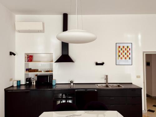 uma cozinha com uma bancada preta e uma luz em The Design Pasta Apartment em Roma