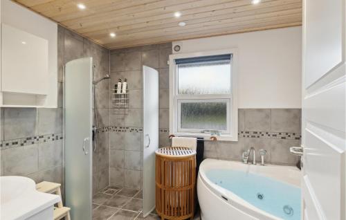 Lovely Home In Strandby With Wifi في Strandby: حمام مع حوض استحمام ودش ومغسلة