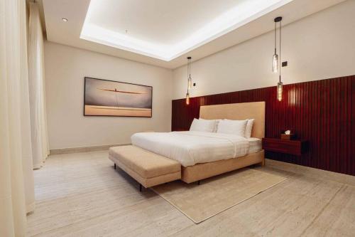 a bedroom with a bed and a bench in it at Nuzul R154 - Elegant Apartment in Riyadh