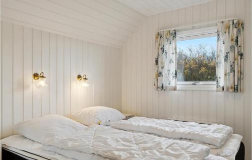 a bedroom with a bed with white sheets and a window at Awesome Home In Blvand With 3 Bedrooms, Wifi And Sauna in Blåvand