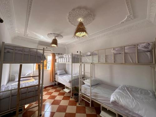 Pokój z 3 łóżkami piętrowymi i sufitem w obiekcie Olas Surf House w mieście Imsouane