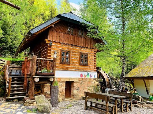uma cabana de madeira com um banco à frente em Hotel Podlesí em Podlesí