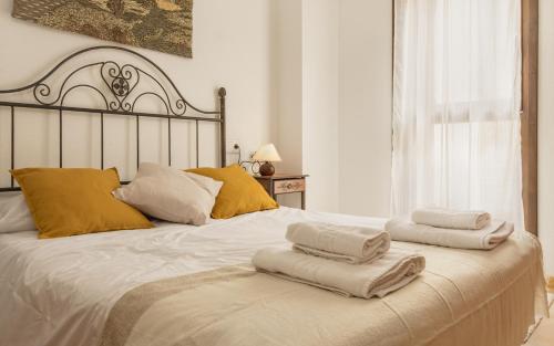 1 dormitorio con 2 toallas en una cama blanca en Alojamiento Sebastian II Biescas, en Biescas