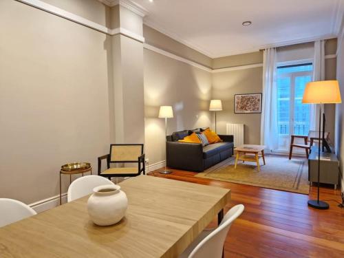 a living room with a table and a couch at GRAN VÍA Bilbao & Parking gratis by ALOHA Bilbao in Bilbao