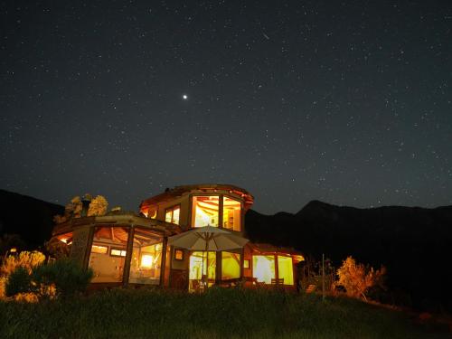 un edificio con luces encendidas en medio de la noche en Swiss Eco Lodge La Linda Loma - Olmué, en Olmué