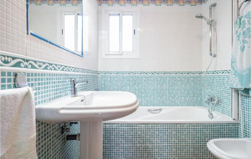 baño azul y blanco con lavabo y bañera en Lovely Home In Frigiliana With Wifi, en Frigiliana