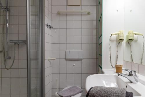 a bathroom with a shower and a toilet and a sink at UplandParcs Bergresidence in Winterberg