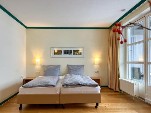 a bedroom with a bed and a large window at UplandParcs Bergresidence in Winterberg