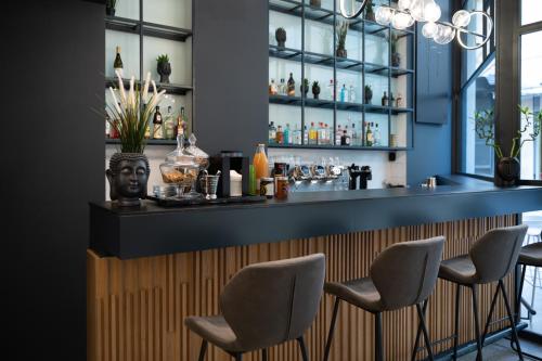 a bar with four chairs in a restaurant at Nema Hotel Athens in Athens