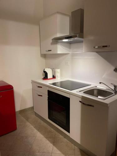 una cucina con lavandino e piano cottura forno superiore di Medea Home a Carosino