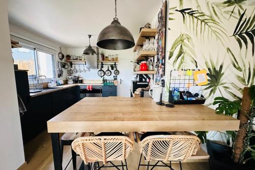 une cuisine avec une table en bois et des plantes dans l'établissement Elegant authentic house close to the beach, à Ploemeur