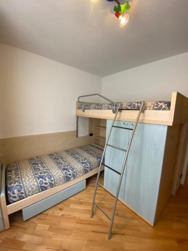 Zimmer mit Etagenbetten und einer Leiter in der Unterkunft Casa Lastei in Pozza di Fassa