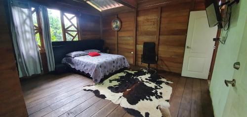 a bedroom with a bed and a cow rug at Finca Mi Carmencita in Mocoa