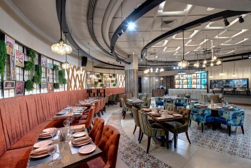 فندق جرانديور البرشاء في دبي: غرفة طعام مع طاولات وكراسي طويلة