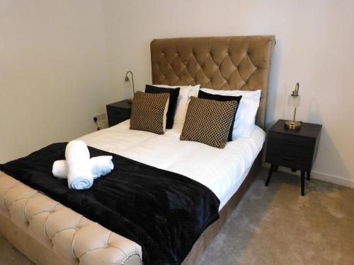 Una cama grande con un animal de peluche blanco. en Fabulous 2 bed apt 10 mins from City Centre, en Glasgow