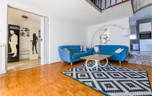 a living room with blue couches and a table at 3 Bedroom Nice Home In Privlaka in Privlaka