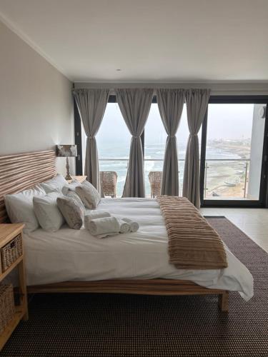 a bedroom with a large bed with a large window at The Pier 27 in Swakopmund