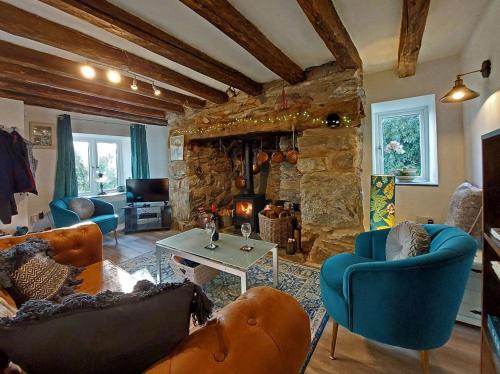 a living room with couches and a stone fireplace at Cae Tudur near Barmouth in Barmouth