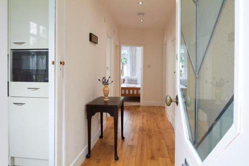 a hallway with a table and a glass door at BOURNECOAST: GROUND FLOOR - GARDEN - WIFI - FM6096 in Iford