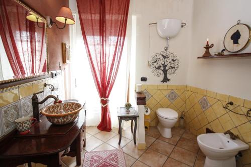 baño con lavabo y aseo y ventana en B&B LA POSADA, en SantʼAntìoco