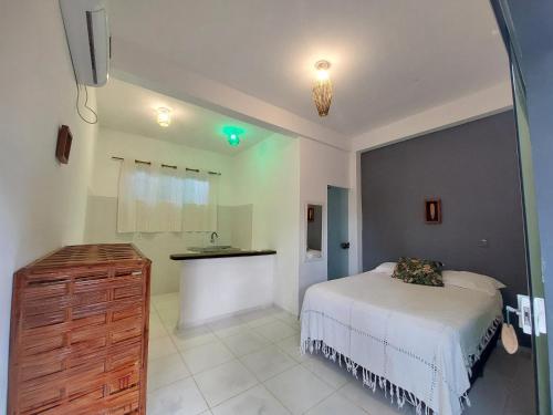 sypialnia z białym łóżkiem i umywalką w obiekcie Taipu In House w mieście Maraú