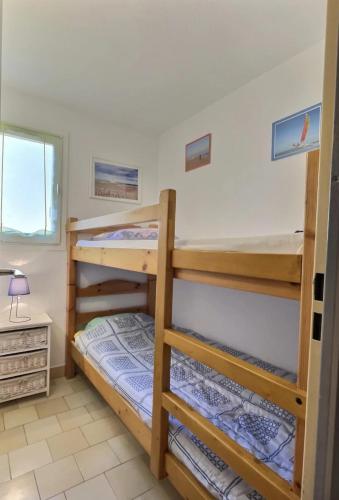 une chambre avec deux lits superposés et un bureau dans l'établissement Virg, à Valras-Plage
