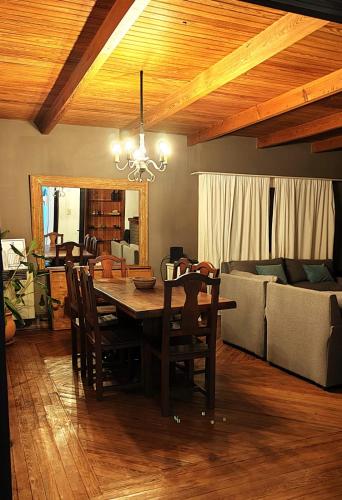 a dining room with a table and chairs and a couch at Hostel Tandil in Tandil
