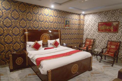 a bedroom with a bed and two chairs at Premier Inn Johar Town Lahore in Lahore