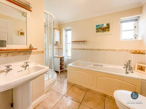 a bathroom with a tub and a sink and a toilet at Wildflower Cottage - Sutton Poyntz in Preston