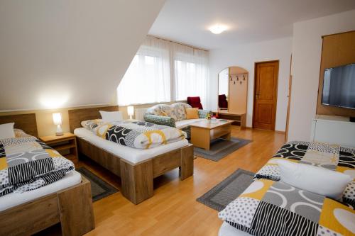 Penzion Harmonia في ليبتوفسكي ميكولاش: غرفة معيشة بها سريرين وأريكة