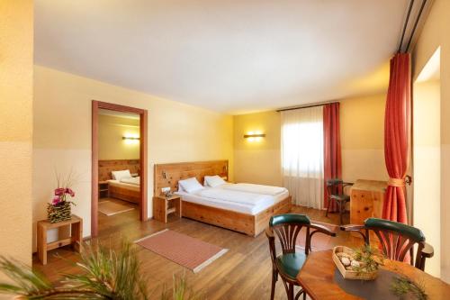 ein Hotelzimmer mit einem Bett und einem Esstisch in der Unterkunft Alpenhof in Seefeld in Tirol