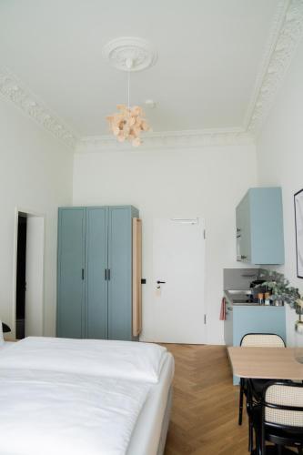 a white bedroom with a bed and a table at Bob W Lübeck Old Town in Lübeck