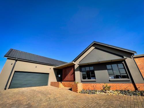 a house with a garage on a clear day at Highland Gate Range View in Dullstroom