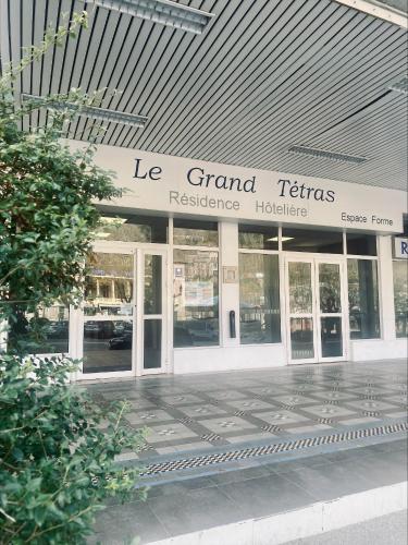 a building with a sign that reads le grand theatresresidersiders at Résidence Le Grand Tétras- SPA THERMAL INCLUS in Ax-les-Thermes