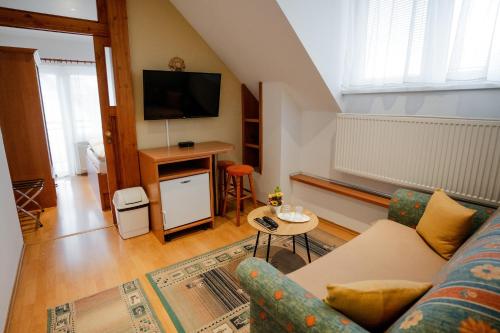 a living room with a couch and a tv at Penzion Harmonia in Liptovský Mikuláš