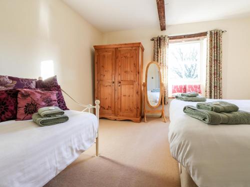 FeethamにあるPursglove Cottageのベッドルーム1室(ベッド2台、ドレッサー付)