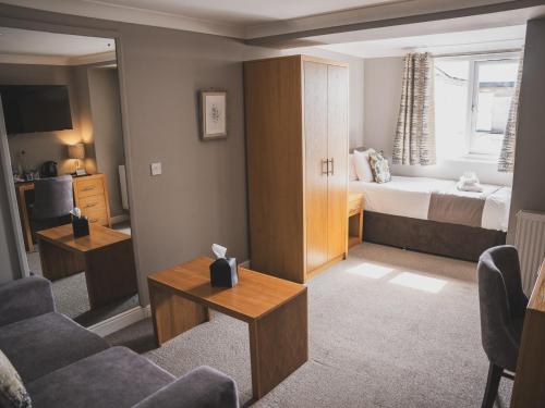 a hotel room with a bed and a living room at Crossways in Wells