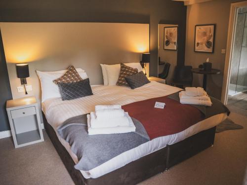 a bedroom with a large bed with towels on it at Crossways in Wells