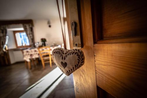 a wooden door with a heart shaped door knob at Lo Ni di Candolle in Gignod