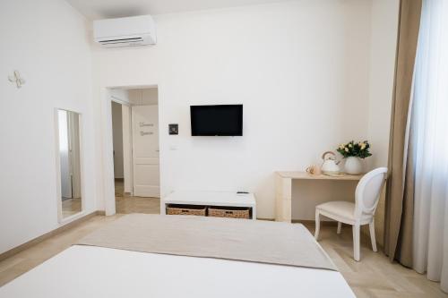 a white room with a table and a tv on a wall at Aurelia Sea View in Torre Canne