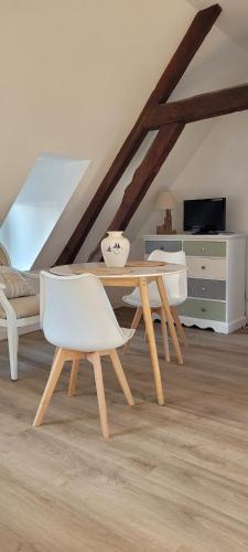 un salon avec une table en bois et des chaises blanches dans l'établissement Studio lumineux proche du centre-ville, à Étaples