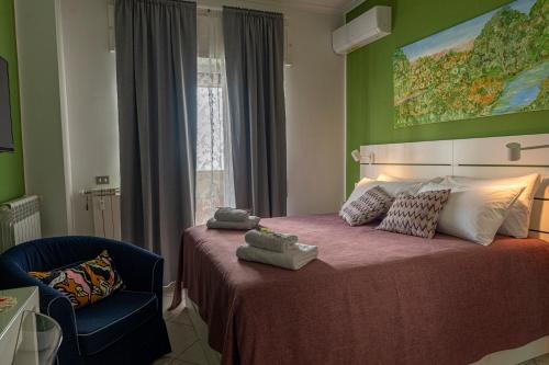 een slaapkamer met een bed en een stoel en een schilderij bij Renza House Chiaia in Napels