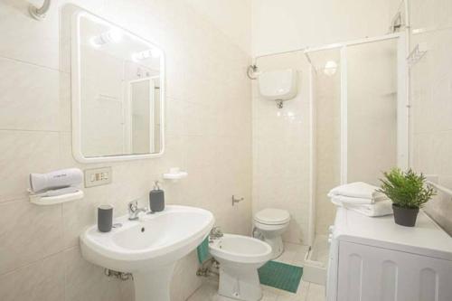 La salle de bains blanche est pourvue d'un lavabo et de toilettes. dans l'établissement Mare Chiaro, à Campese