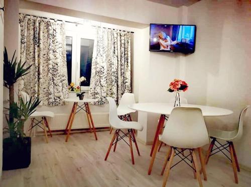 a living room with a table and chairs and a window at Apartament Daria in Tîrgu Ocna
