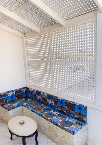 a room with a table and a bench with blue tiles at Dar Ezzahra in Tozeur